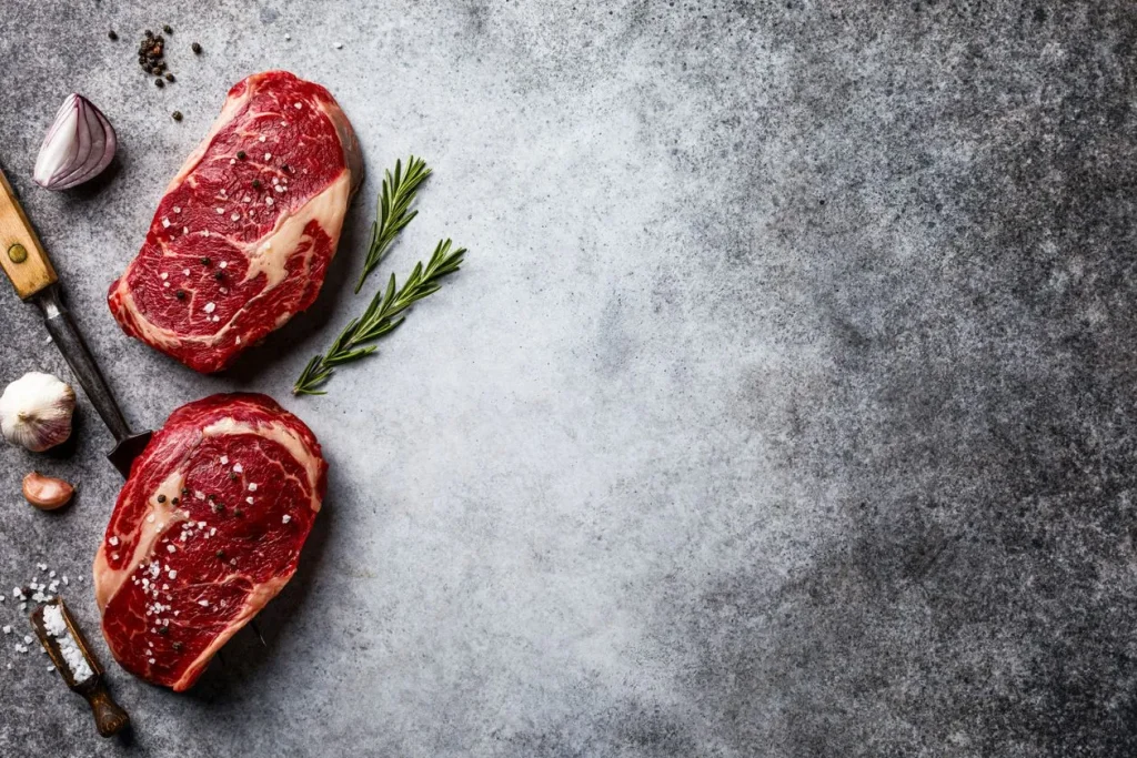 what seasonings are allowed on carnivore diet; two raw steaks on a table with garlic and pepper